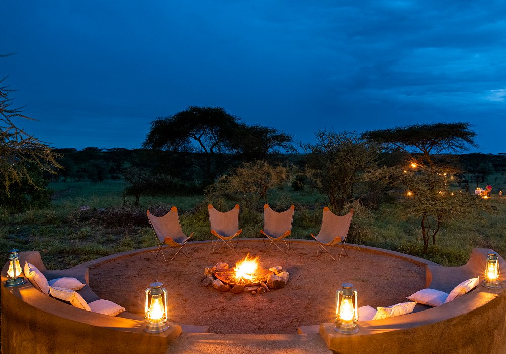 Enjoying a sundowner at the campfire in the middle of the Serengeti