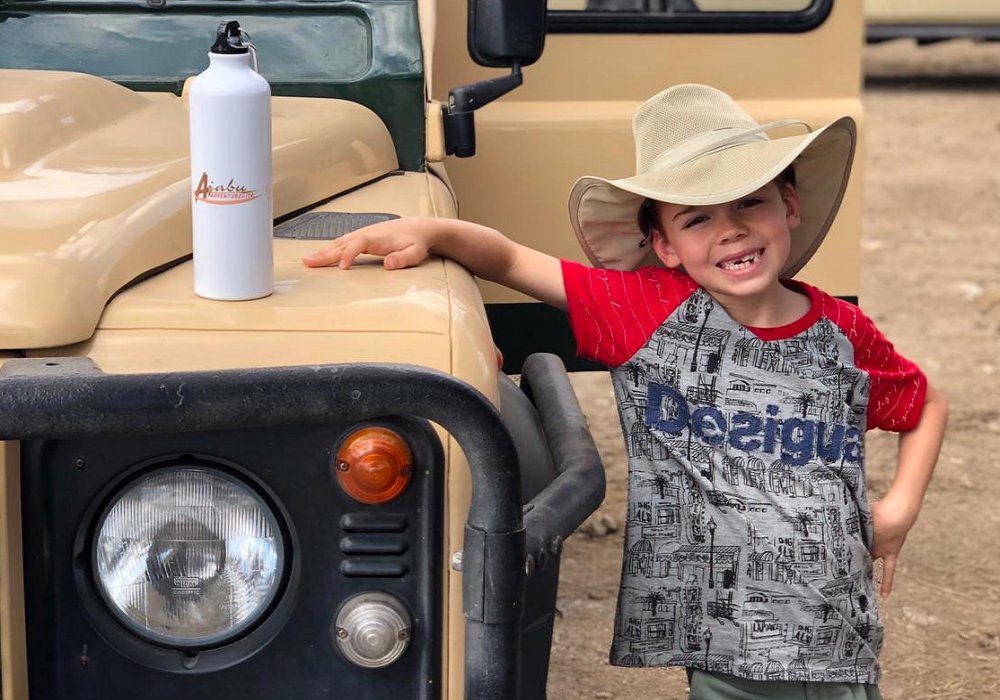 Child on safari in Tanzania with sustainable water bottle from Ajabu Adventures